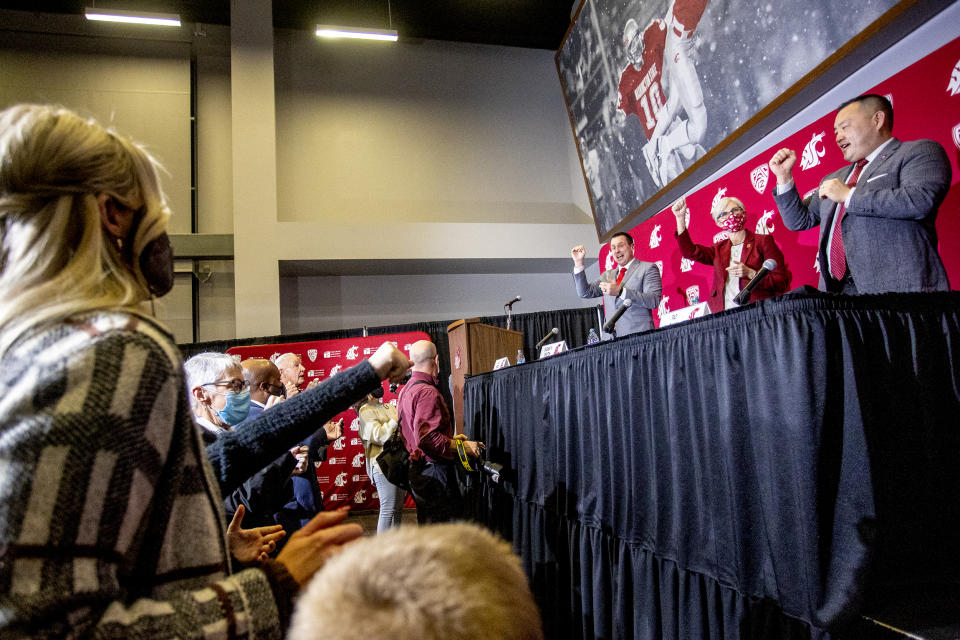 New Washington State football coach Jake Dickert, third from right, reacts during the playing of the school's fight song at a news conference Thursday, Dec. 2, 2021, in Pullman, Wash. Dickert, 38, was elevated last week from interim coach after the team pounded rival Washington in the annual Apple Cup game in Seattle. (August Frank/Lewiston Tribune via AP)