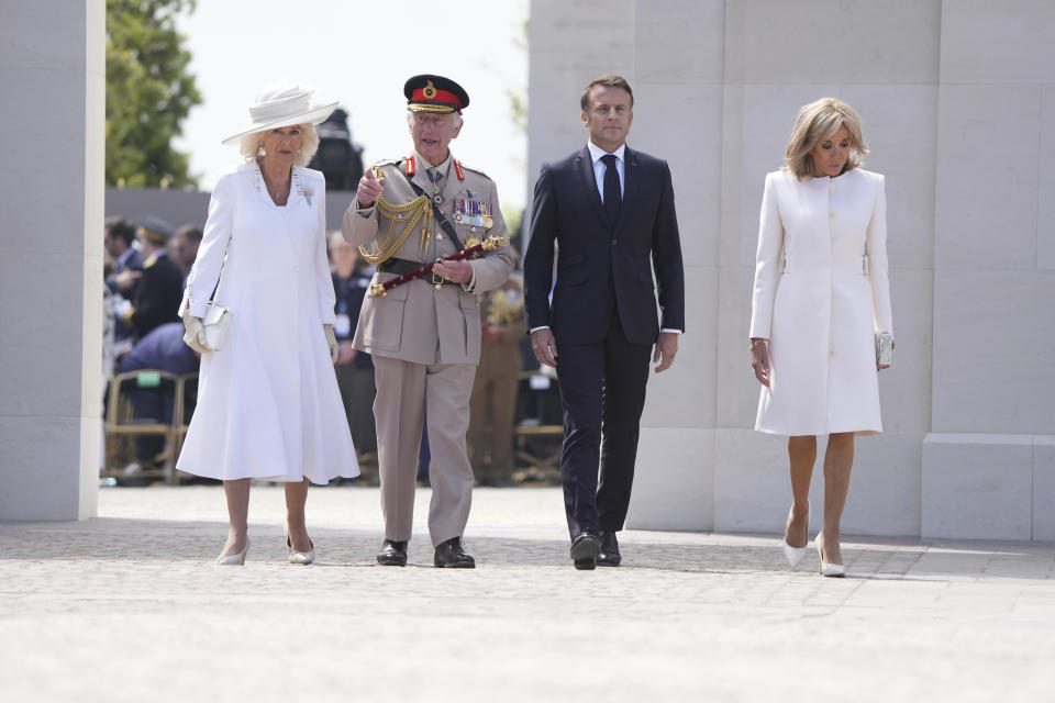 From left, Britain's Queen Camilla, King Charles III, President of France Emmanuel Macron, and Brigitte Macron walk through the memorial wall during the UK national commemorative event for the 80th anniversary of D-Day, held at the British Normandy Memorial in Ver-sur-Mer, Normandy, France, Thursday June 6, 2024. (Gareth Fuller, Pool Photo via AP)