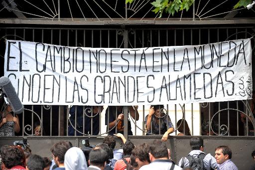 Un grupo de estudiantes de la ACES (Asamblea Coordinadora de Estudiantes de Secundaria) protestan tras ocupar el comando de la candidata de izquierda y hoy presidenta de Chile Michelle Bachelet durante las elecciones generales, el 17 de noviembre de 2013, en Santiago. (AFP | Hector Retamal)