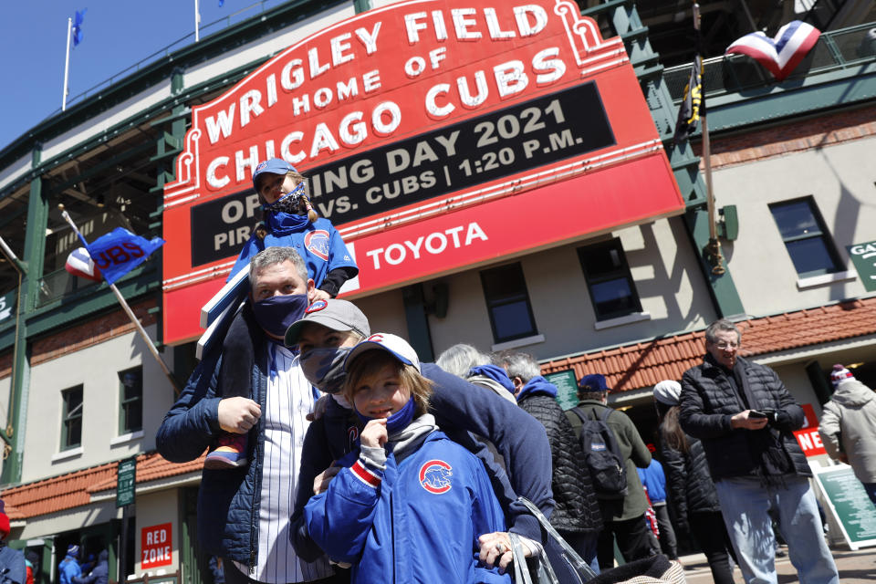 A family poses for a photo outside of Wrigley Field on the opening day baseball game between the Chicago Cubs and the Pittsburgh Pirates, Thursday, April 1, 2021, in Chicago. From New York to Seattle and everywhere in between, it is a much different opening day in 2021. Fans are back at the ballpark after they were shut out during the regular season last year because of the coronavirus pandemic. (AP Photo/Shafkat Anowar)