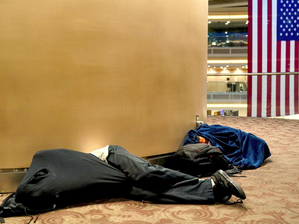 Two passengers sleep on the floor at Hartsfield-Jackson Atlanta International Airport ahead of the Fourth of July holiday in Atlanta, Georgia, U.S., July 1, 2022.