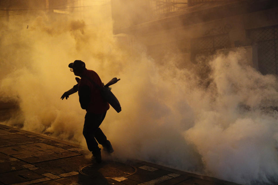 A protester against the reelection of President Evo Morales hurls a tear gas canister back at police during clashes in La Paz, Bolivia, Thursday, Oct. 31, 2019. Violence has escalated since Morales was declared the winner of the Oct. 20 vote amid delays in the vote count. The opposition alleges the outcome was rigged to give Morales enough of a majority to avoid a runoff election; the president denies any irregularities. (AP Photo/Juan Karita)