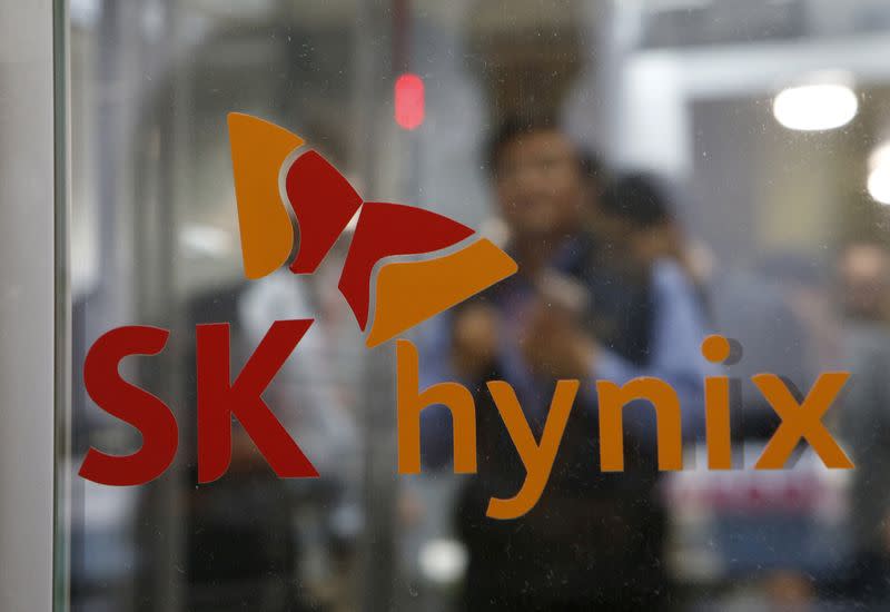 FILE PHOTO: Employee walk past the logo of SK Hynix at its headquarters in Seongnam