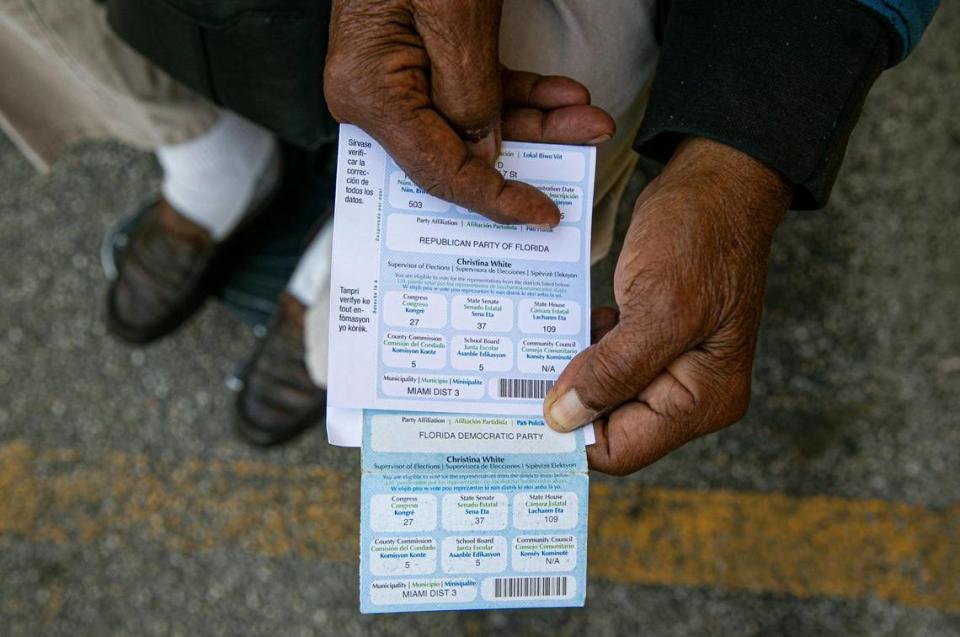 Juan Salazar, 77, holds his voter registration cards, outside of his apartment home in Little Havana, Florida on Saturday, February 5, 2022. Salazar explained his party affiliation was changed from Democrat to Republican without his permission.