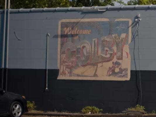 sign on the side of a building that says welcome to colby in along for the ride