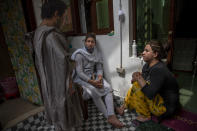Transgender Kashmiris Azimi Bhat, right, Hinna Bhat, center and Khushi Mir converse outside their guru's house at the end of a special meet of their community members in Srinagar, Indian controlled Kashmir, Thursday, June 3, 2021. Mir, along with four young boys, has created a volunteer group distributing food kits to transgender community members. (AP Photo/ Dar Yasin)