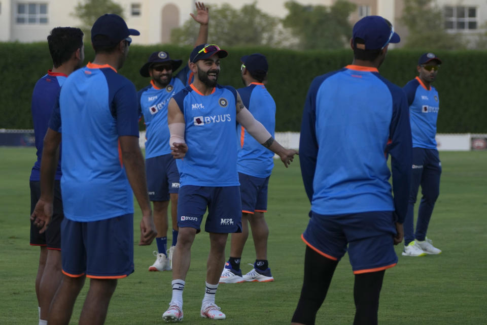 India's Virat Kohli, center, shares a light moment with teammates during a training session at ICC ground ahead of their T20 cricket match of Asia Cup against Pakistan in Dubai, United Arab Emirates, Friday, Aug. 26, 2022. (AP Photo/Anjum Naveed)