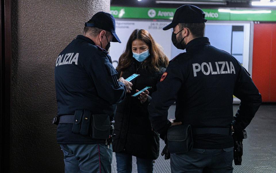 Police officers check Covid-19 health passes of passengers in Milan - Getty