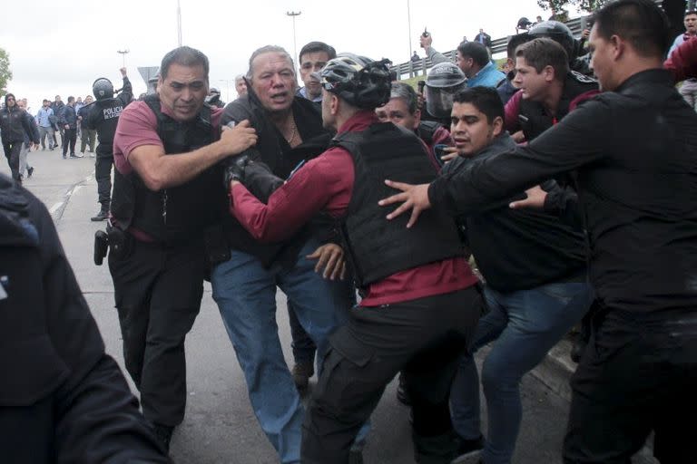 Sergio Berni, el ministro de seguridad de la provincia de Buenos Aires, en el centro, es extraído de una protesta en Buenos Aires, el lunes 3 de abril de 2023. Berni fue atacado durante una protesta de conductores de autobuses luego del asesinato de un compañero de trabajo. (AP Foto/Andrés Pelozo)