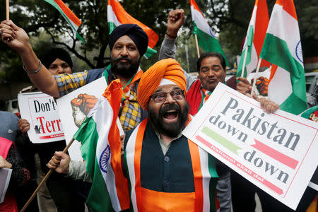 People hold national flags and placards as they celebrate after Indian authorities said their jets conducted airstrikes on militant camps in Pakistani territory, in New Delhi, India, February 26, 2019. REUTERS/Adnan Abidi