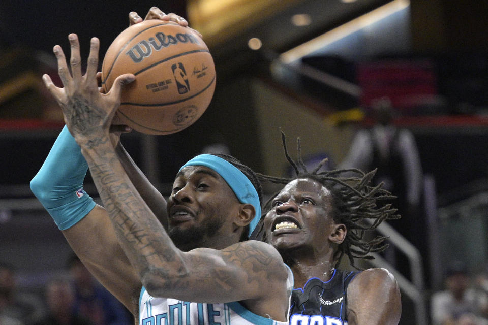 Charlotte Hornets forward Jalen McDaniels, left, and Orlando Magic center Bol Bol battle for a rebound during the first half of an NBA basketball game, Friday, Oct. 28, 2022, in Orlando, Fla. (AP Photo/Phelan M. Ebenhack)