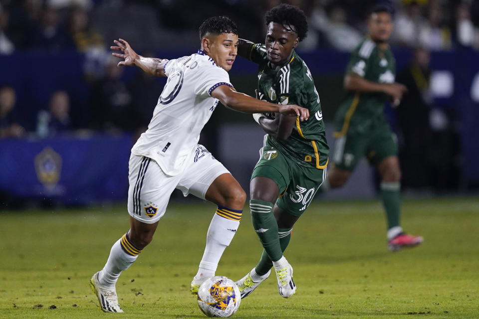 LA Galaxy midfielder Edwin Cerrillo, left, and Portland Timbers midfielder Santiago Moreno vie for the ball during the first half of an MLS soccer match Saturday, Sept. 30, 2023, in Carson, Calif. (AP Photo/Ryan Sun)
