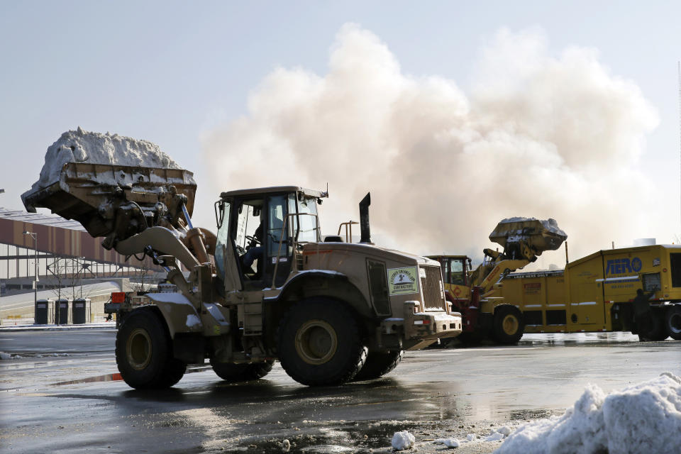 A large machinery melts snow as workers remove snow from parking lots at MetLife stadium in East Rutherford, N.J., Wednesday, Dec. 18, 2013. Officials demonstrated snow removal and melting machinery and outlined emergency weather scenarios and contingency plans for the Super Bowl in February. (AP Photo/Mel Evans)