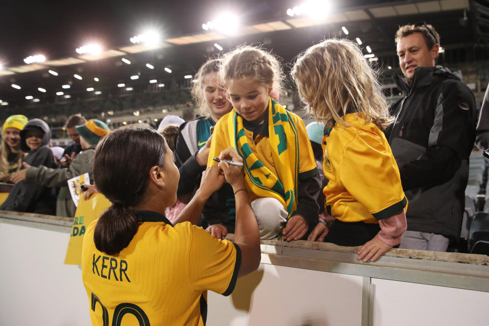 Sam Kerr, pictured here signing an autograph for a young fan after the Matildas' win.