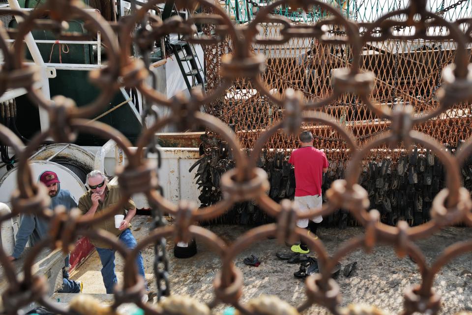 Fishermen repair the dredges aboard the Daddy's Girl scalloper docked in New Bedford.