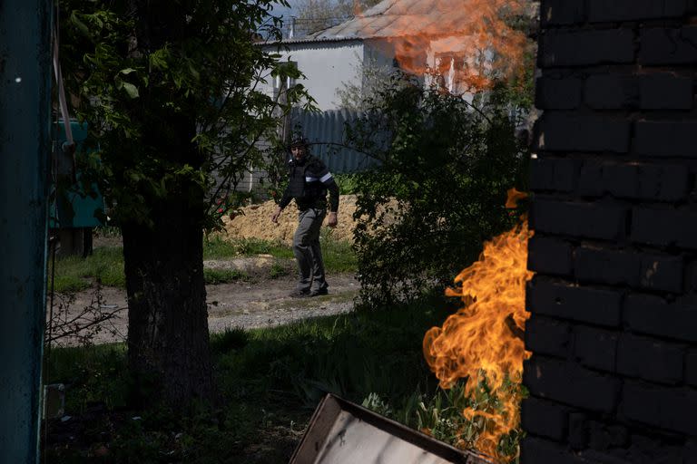 Oleg, un trabajador de la construcción convertido en voluntario, camina junto a una casa en llamas mientras busca a los residentes para evacuar en Ruska Lozova, Ucrania, el miércoles. (Tyler Hicks/The New York Times)
