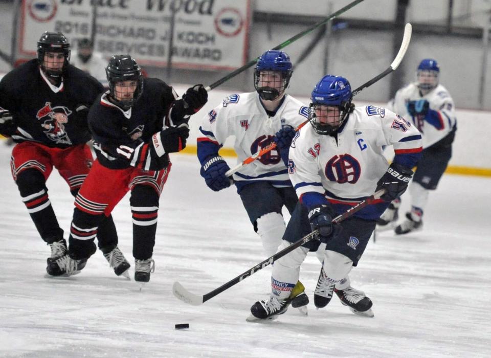 Quincy's Will Martin, right, leads a charge down the ice with North Quincy defenders in pursuit during the Holiday Tournament at the Quincy Youth Arena, Tuesday, Dec. 27, 2022.