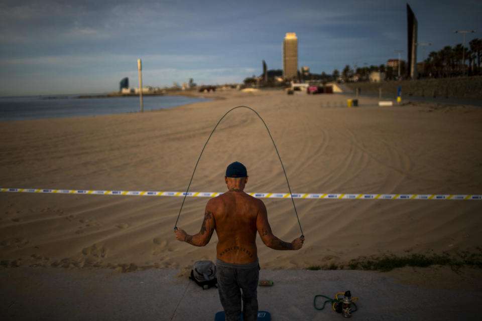 A man exercises next to a closed beach in Barcelona, Spain, Saturday, May 2, 2020. Spaniards have filled the streets of the country to do exercise for the first time after seven weeks of confinement in their homes to fight the coronavirus pandemic. People ran, walked, or rode bicycles under a brilliant sunny sky in Barcelona on Saturday, where many flocked to the maritime promenade to get as close as possible to the still off-limits beach. (AP Photo/Emilio Morenatti)