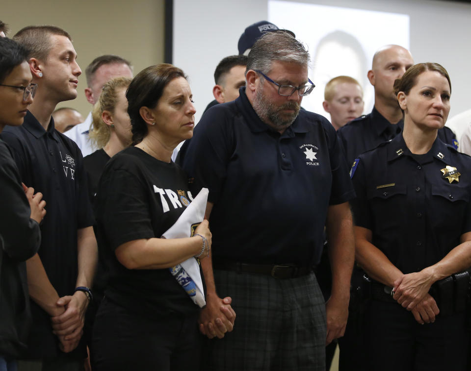 CORRECTS FIRST NAME TO KELLEY, NOT KELLY - Kelley and Denis O'Sullivan, the parents of slain Sacramento Police officer Tara O'Sullivan, hold hands during a news conference in Sacramento, Calif., Tuesday, June 25, 2019. Denis O'Sullivan told reporters that any notion that the Sacramento Police Department was responsible for her death was extremely offensive and hurtful. It took rescuers 45 minutes to reach Tara O'Sullivan after she was shot by gunman, who kept shooting at police, during a domestic violence call last week. (AP Photo/Rich Pedroncelli)