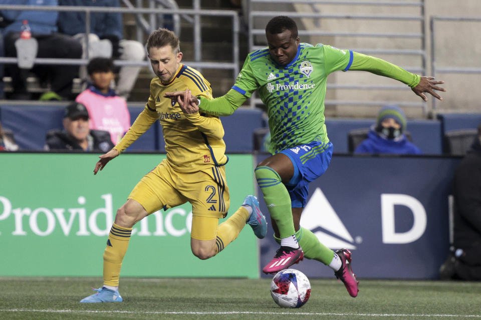 Real Salt Lake defender Andrew Brody (2) and Seattle Sounders defender Nouhou Tolo chase the ball during the first half of an MLS soccer match Saturday, March 4, 2023, in Seattle. (AP Photo/Jason Redmond)