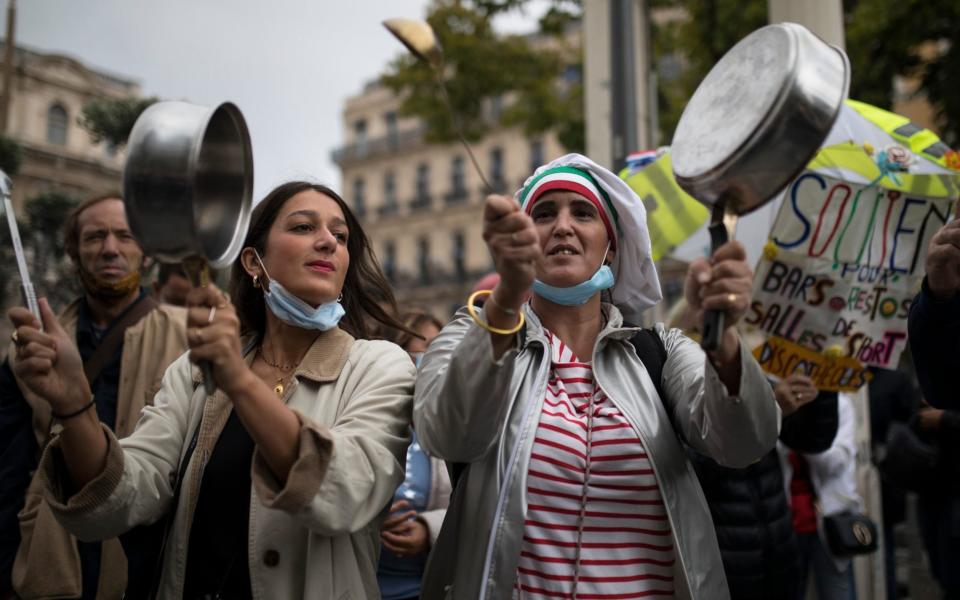 Restaurant owners clang spoons and casserolesat a demonstration against restaurant and bar closures in Marseille, southern France, Friday Oct. 2, 2020.  - Daniel Cole/ AP