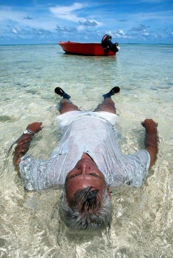 An man relaxes in the waters off Tuvalu as rising sea levels inundate many of his country's low islands. Tiny Pacific nations which are most at threat from rising seas have vowed to dump diesel and other dirty expensive fuels blamed for causing global warming and replace them with clean sources