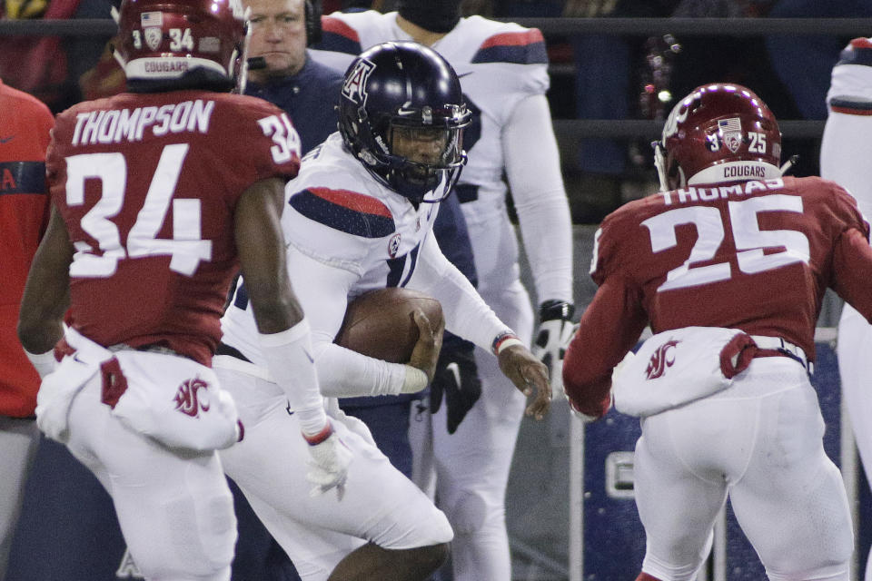 Arizona quarterback Khalil Tate, center, runs with the ball while pursued by Washington State safety Skyler Thomas (25) and safety Jalen Thompson (34) during the first half of an NCAA college football game in Pullman, Wash., Saturday, Nov. 17, 2018. (AP Photo/Young Kwak)