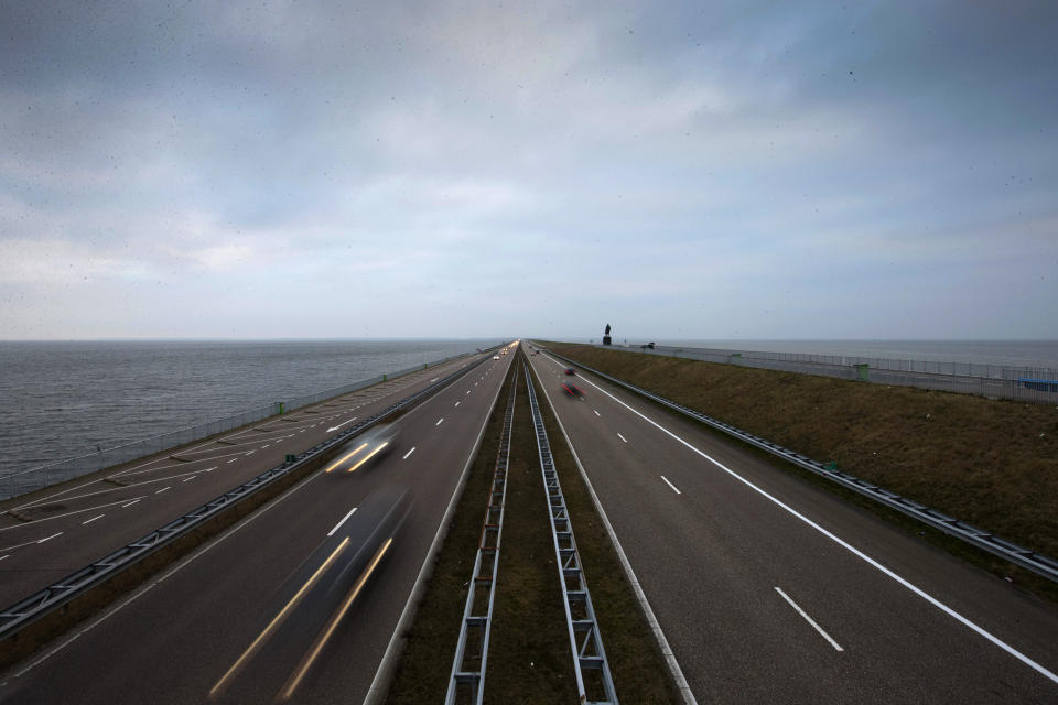 In this photo taken Sunday March 8, 2015, traffic moves over the Afsluitdijk, a dike and causeway, separating Wadden Sea, right, from western europe's largest lake, IJsselmeer lake, left, between Den Oever and Wieringen, northern Netherlands. Rising in a thin line through the surface of waters separating the provinces of North Holland and Friesland, the 87-year-old Afsluitdijk is one of the low-lying Netherlands' key defenses against the sea. With climate change bringing more powerful storms and rising sea levels, it's getting a major makeover. (AP Photo/Peter Dejong)