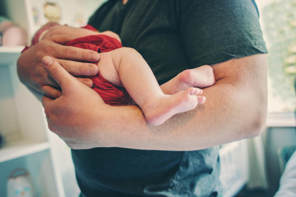 A father holding a newborn baby