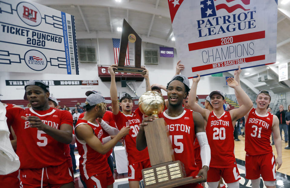 Boston University's Jonas Harper (15) holds the trophy after beating Colgate in the NCAA Patriot League Conference basketball championship at Cotterell Court, Wednesday, March 11, 2020, in Hamilton, N.Y. (AP Photo/John Munson)