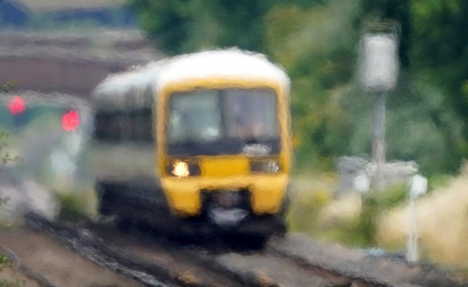 A train passes through heat haze on a railway line near Ashford in Kent (PA)