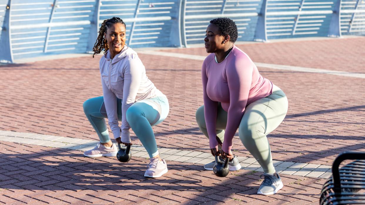  Two women doing kettlebell goblet squats 