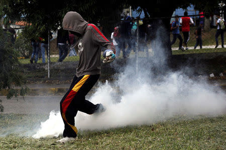 A demonstrator kicks back a tear gas canister during a protest against Venezuelan President Nicolas Maduro's government in San Cristobal, Venezuela. REUTERS/Carlos Eduardo Ramirez