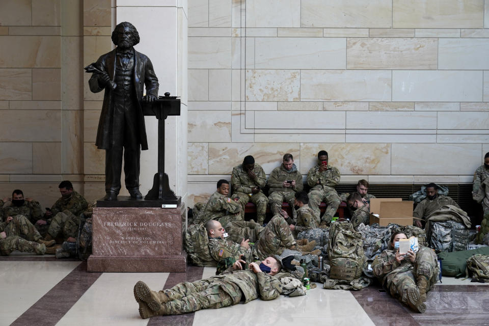 Troops hold inside the Capitol Visitor's Center to reinforce security at the Capitol in Washington, Wednesday, Jan. 13, 2021. The House of Representatives is pursuing an article of impeachment against President Donald Trump for his role in inciting an angry mob to storm the Capitol last week.. (AP Photo/Alex Brandon)