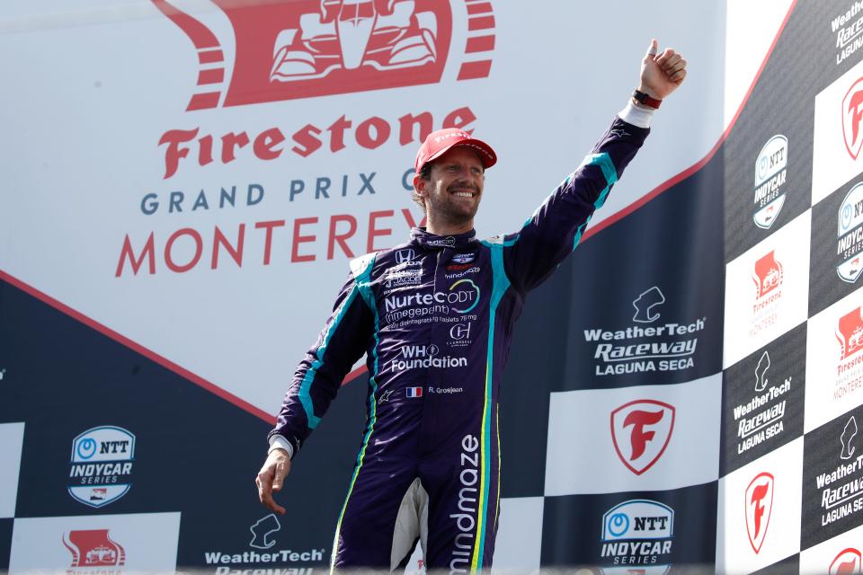 Romain Grosjean waves to fans as they cheer him on after he finished third Sunday at Laguna Seca.