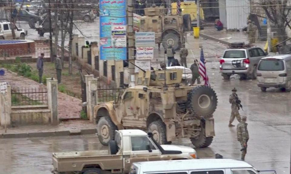 An image grab taken from a video obtained by AFPTV on Wednesday shows US troops gathered at the scene of a suicide attack in the northern Syrian town of Manbij.