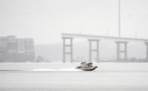 A boat crosses along the Patapsco River, Wednesday, March 27, 2024, as the remnants of the Francis Scott Key Bridge are seen from Dundalk, Md. (Kaitlin Newman/The Baltimore Banner via AP)