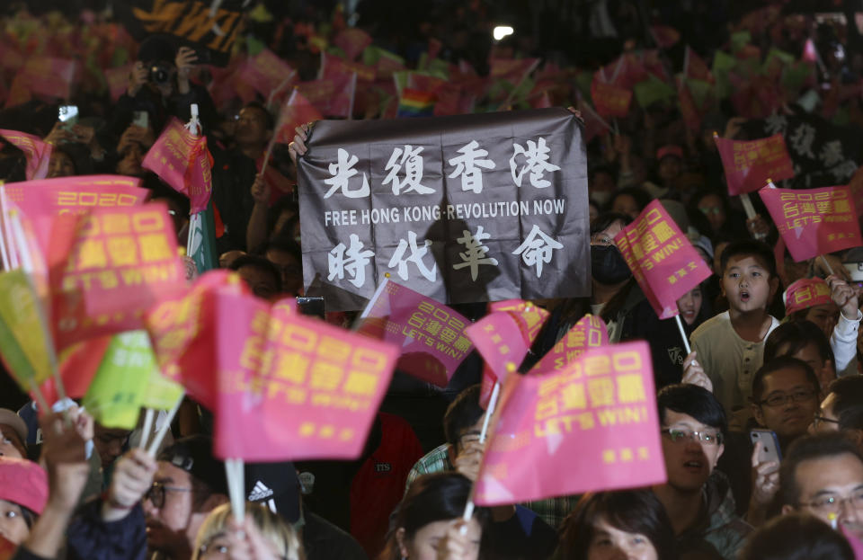 Hong Kong supporters of Taiwan's 2020 presidential election candidate, Taiwan president Tsai Ing-wen hold slogan as supporters gather to watch the early election returns in Taipei, Taiwan, Saturday, Jan. 11, 2020. (AP Photo/Chiang Ying-ying)