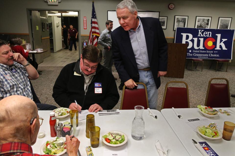 In this Jan. 24, 2014 photo, Weld County District Attorney Ken Buck, top, seen as the front-runner in the GOP primary for the upcoming U.S. Senate race, speaks with supporters during a campaign dinner event at Johnson's Corner, a truck stop and diner in Johnstown, Colo. Buck narrowly lost a 2010 Senate bid after being hammered for statements that angered some women and gays. Now his candidacy will be a test of whether a tea party favorite can do better in 2014. (AP Photo/Brennan Linsley)