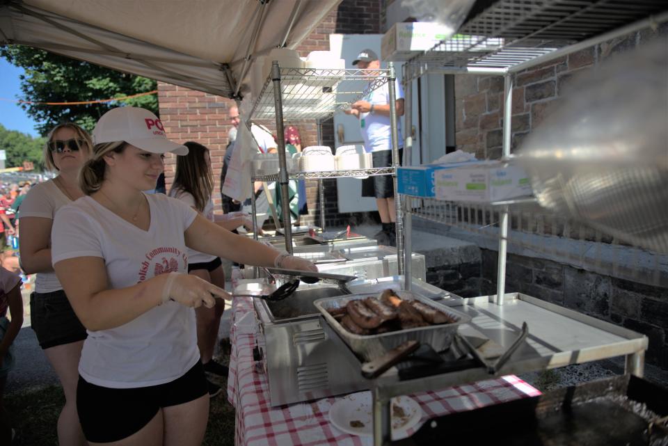 Volunteers from Utica's Polish Community Club serve sausages, potato and cheese pierogis to hungry runners and visitors at the Boilermaker's Post Race Party Sunday, July 10.