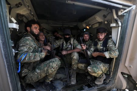 Turkey-backed Syrian rebel fighters sit inside a military vehicle near the border town of Tel Abyad