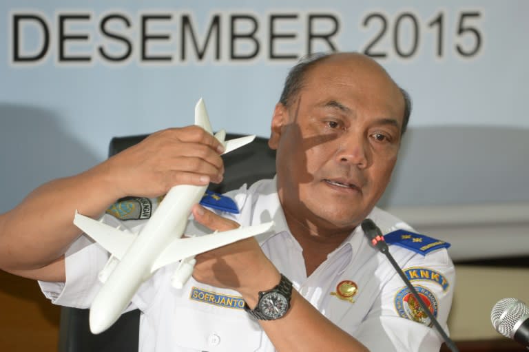 Soejanto Tjahjono, head of Indonesia's National Transportation Safety Committee (KNKT), holds a plane model as he speaks to journalists in Jakarta on December 1, 2015