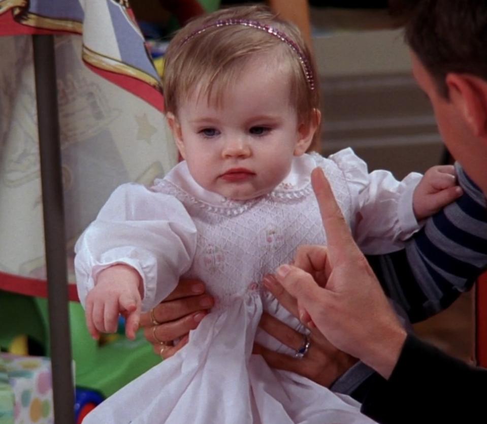 Emma sits with Monica and Chandler during Emma's first birthday celebration