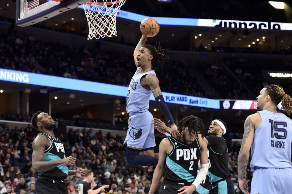 Memphis Grizzlies guard Ja Morant (12) goes up for a dunk over Portland Trail Blazers forward Trendon Watford (2) in the second half of an NBA basketball game, Wednesday, Feb. 1, 2023, in Memphis, Tenn. (AP Photo/Brandon Dill)