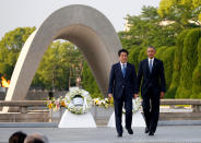 <p>President Barack Obama and Japanese Prime Minister Shinzo Abe walk in front of a cenotaph after they laid wreaths at Hiroshima Peace Memorial Park in Hiroshima, Japan May 27, 2016. (Photo: Carlos Barria/Reuters) </p>