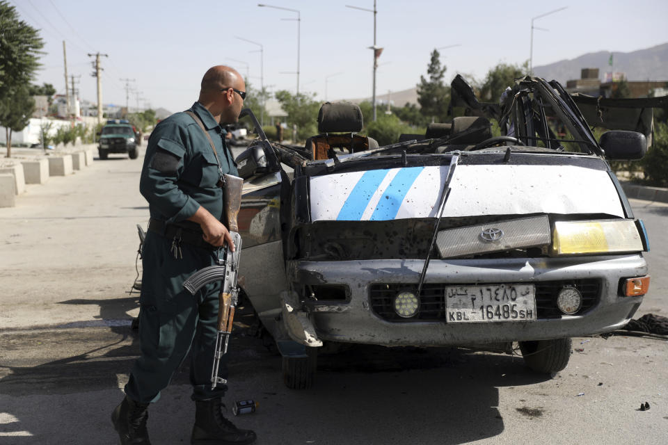 An Afghan security personnel inspect the site of a bomb explosion in Kabul, Afghanistan, Thursday, June 3, 2021. Police say a bomb has ripped through a minivan in the western part of the Afghan capital Kabul, killing at least four people. No one took responsibility for the attack in the neighborhood, which is largely populated by the minority Hazara ethnic group who are mostly Shiite Muslims. (AP Photo/Rahmat Gul)