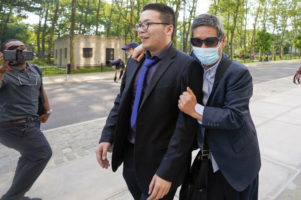 FILE - Zhu Yong, right, tries to shield himself from photographers as he leaves federal court, May 31, 2023, in the Brooklyn borough of New York. Zhu was one of three met accused of participating in an escalating series of scare tactics aimed at repatriating a former Chinese official who was living quietly in New Jersey. Zhu was convicted of acting as an illegal foreign agent, stalking, interstate stalking conspiracy and conspiring to act as an illegal foreign agent. (AP Photo/Mary Altaffer, File)