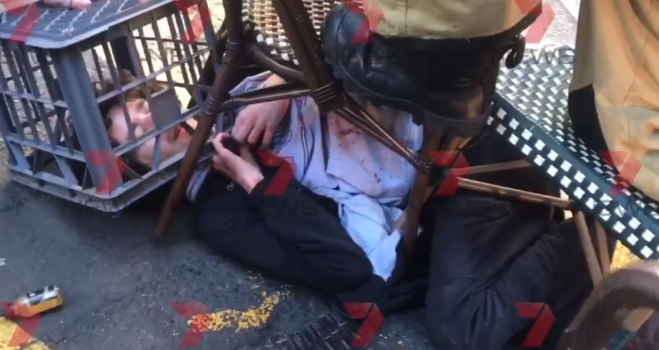 Screengrab taken with permission from a video issued by 7 News of a man being tackled with a milk crate and chairs by members of the public in Sydney, Australia, following a knife attack.