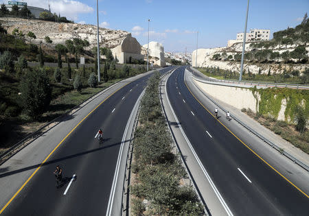 Children ride their bicycles in an empty street in Jerusalem during the Jewish holiday of Yom Kippur, September 19, 2018. Most Israeli Jews refrain from driving during the 25-hour period. REUTERS/Ammar Awad