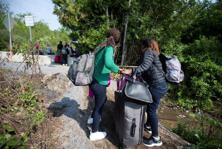 FILE PHOTO: Women claiming to be from Burundi cross the US-Canada border into Quebec from Champlain, New York, August 3, 2017. REUTERS/Christinne Muschi/File Photo